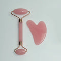 Stainless steel facial massage board set with heart-shaped eye roller and scraping plate on simple packaging