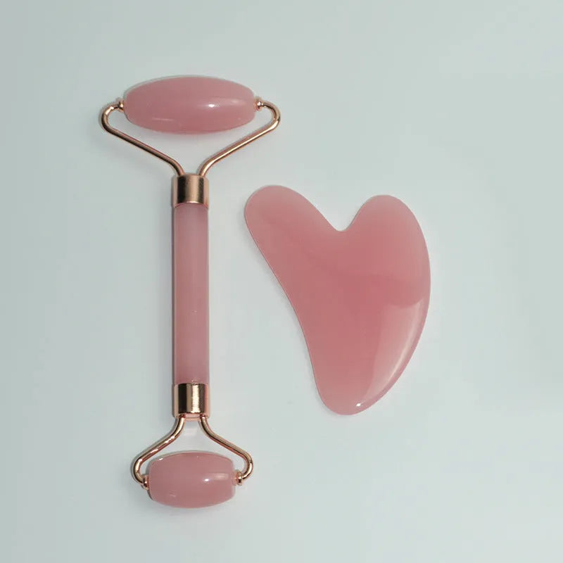 Stainless steel facial massage board set with heart-shaped eye roller and scraping plate on simple packaging