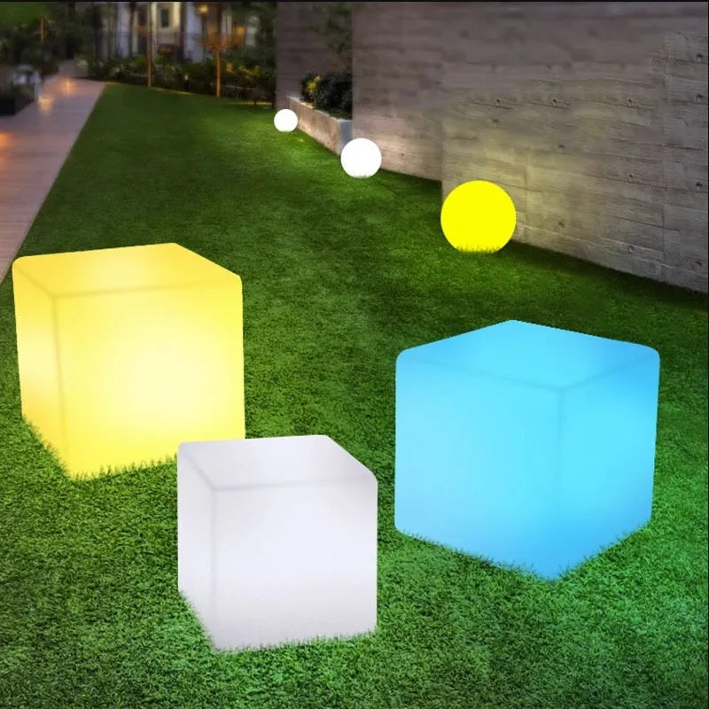 Modern square white LED cube light stool outdoors on a patio.