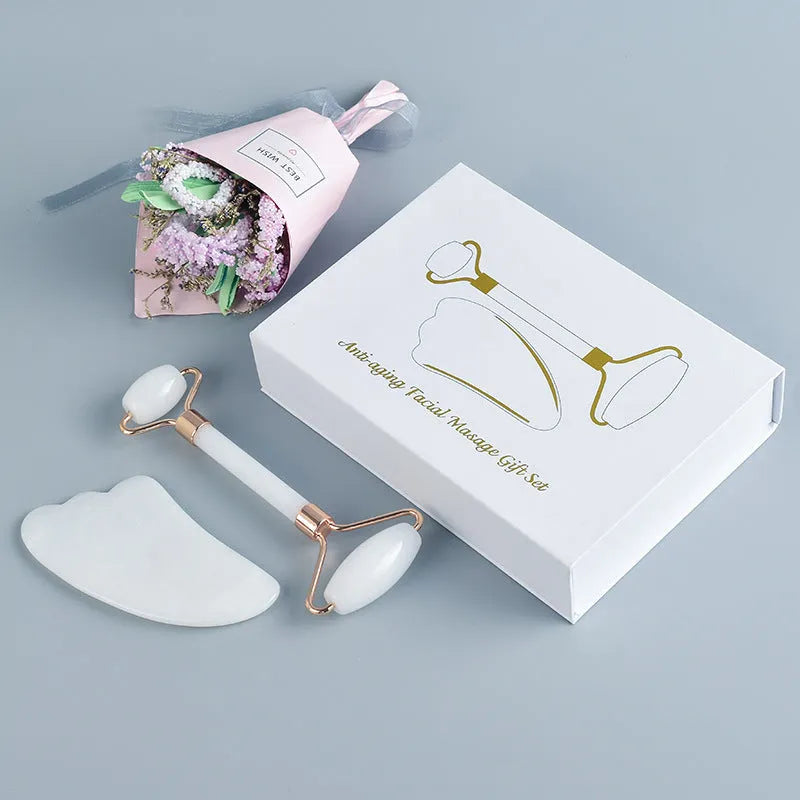 White jade double-headed facial roller and gua sha scraping board set on a storage tray.