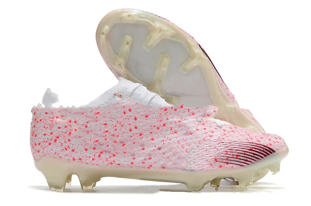 Men's football boots with knitted upper, FG studs, and built-in air cushion on green grass