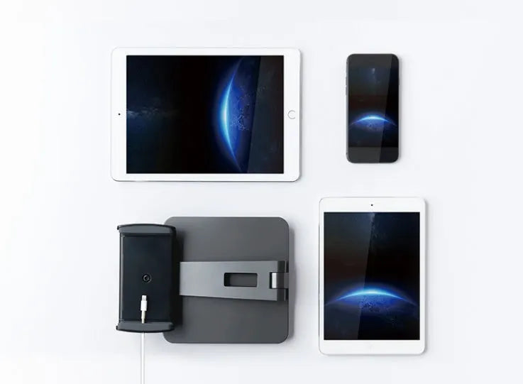 Folding aluminium and black plastic phone tablet stand on a desk, showing 360 degree rotation base.