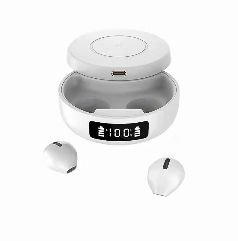 Mini black wireless semi-in-ear headphones sitting in their open white charging case on a table.