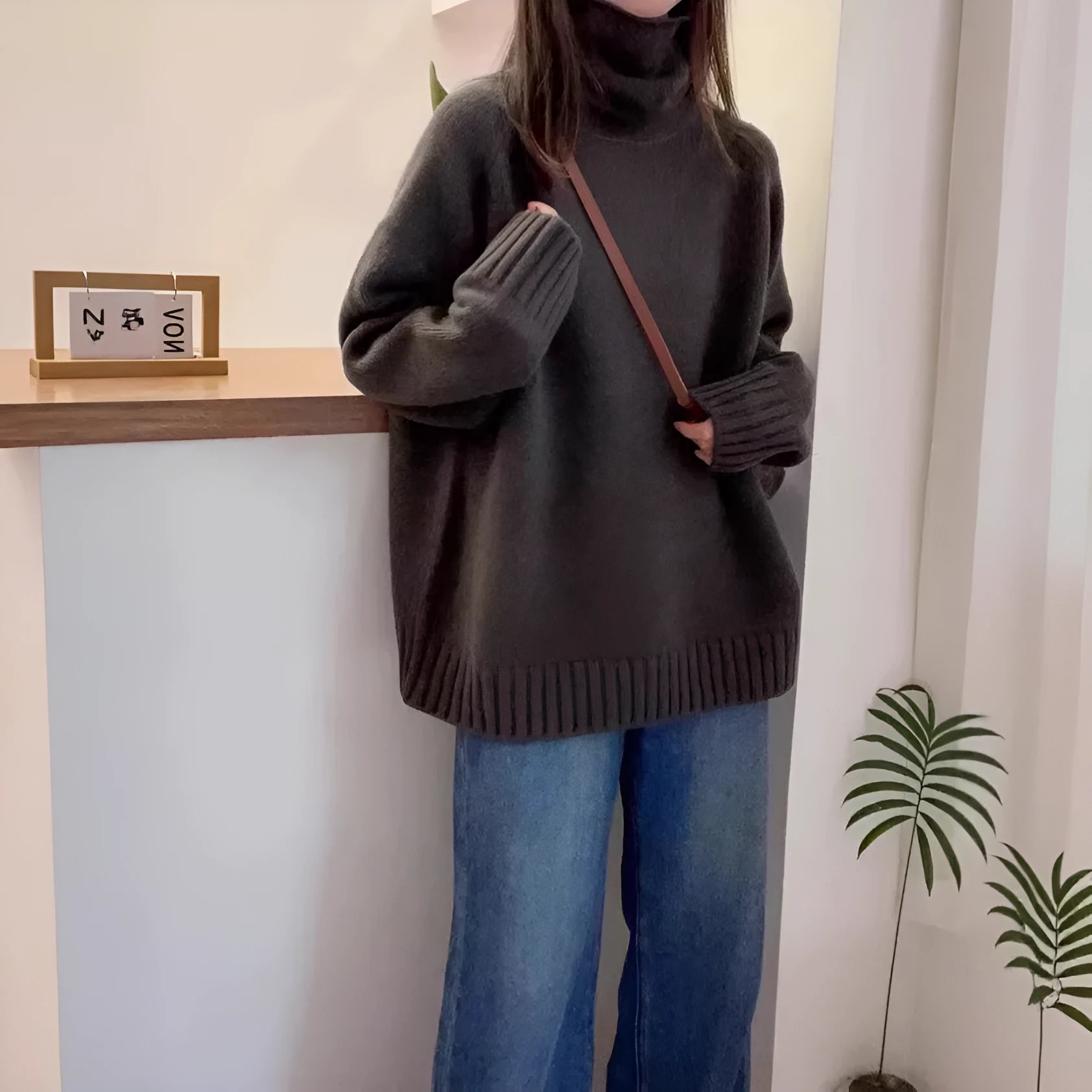 Women's loose grey turtleneck sweater with a thick knit and textured curling pile collar.