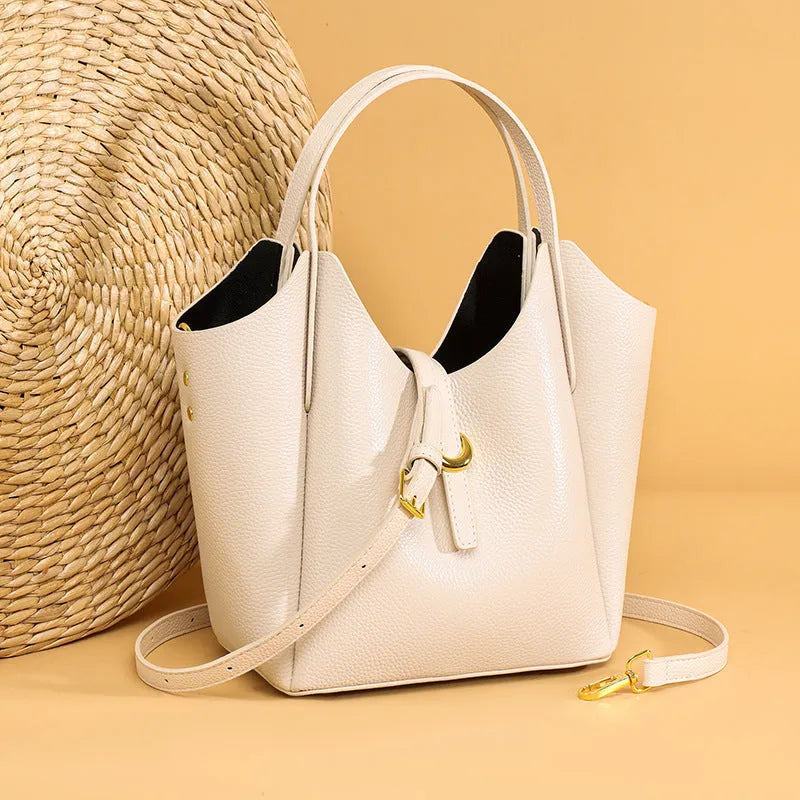 Genuine leather women's hand holding bucket bag in European American retro style with visible sewing thread detailing