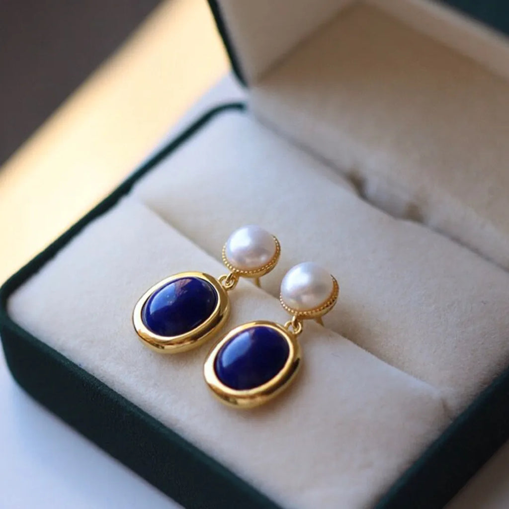 A pair of simple 925 silver earrings with a blue lapis lazuli pearl and auspicious pattern details.