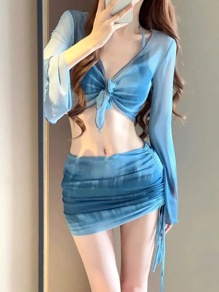Women's blue four-piece bikini swimsuit set showing shirt, bra, high-waist brief, and skirt for swimming and fitness