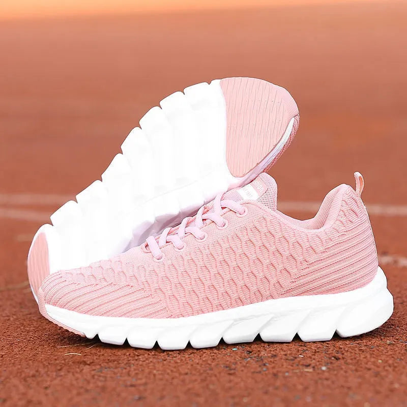 Women's running shoes with fly weave upper in black, pink, or white on a wear-resistant outsole.