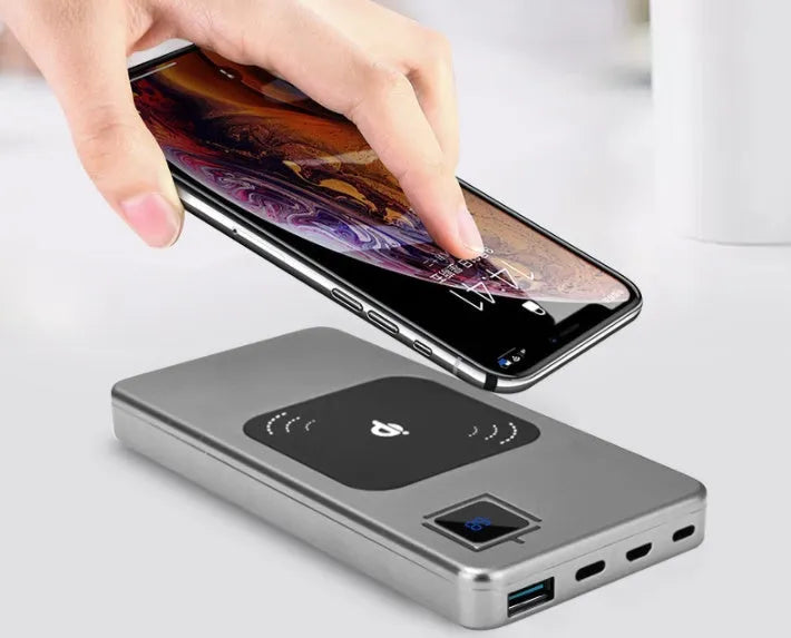 Black portable power bank with LCD screen showing battery level, next to silver, red, and blue colour options.
