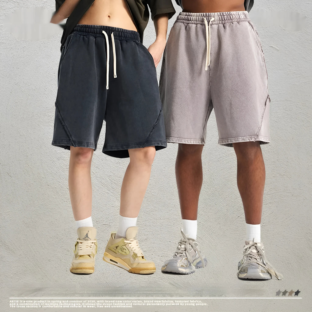 Man wearing batik-washed black cotton shorts with a loose fit and a retro patch on the leg.