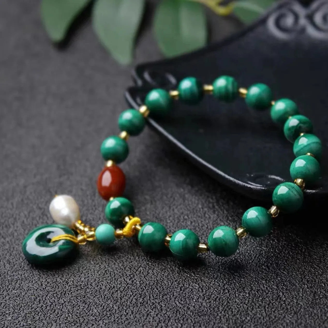Natural malachite bracelet with green banded barrel beads on a neutral background