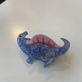 Dinosaur acrylic jaw clip hairpin in six colours including pink pterosaur and green stegosaurus on neutral background