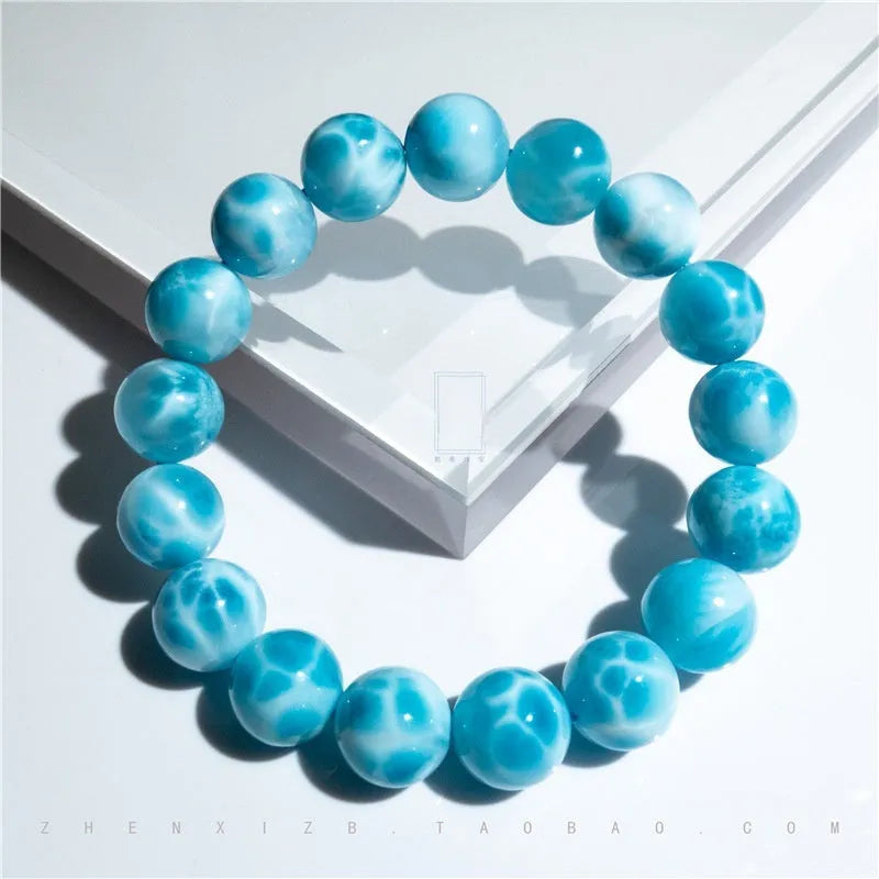 Blue Maillard-style Bodhi bracelet with a sea-pattern crystal stone and pearl accents on a wrist.
