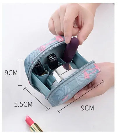 A plain blue cloth cube-shaped makeup storage bag on a table.