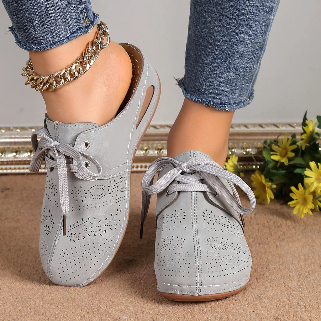 Women's black suede lace-up wedge slippers with a hollow out design and rubber sole.
