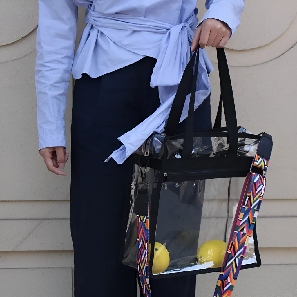 Women's transparent PVC shoulder messenger bag showing front organisation and double strap connector