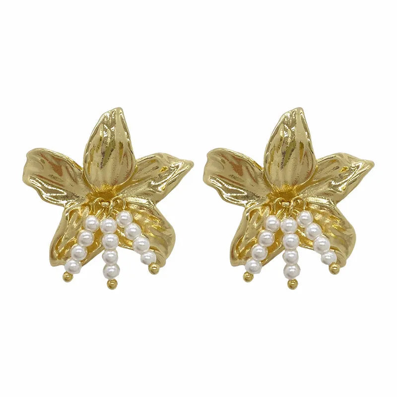 Gold pearl flower earrings with metal post back on white background, exaggerated floral shape