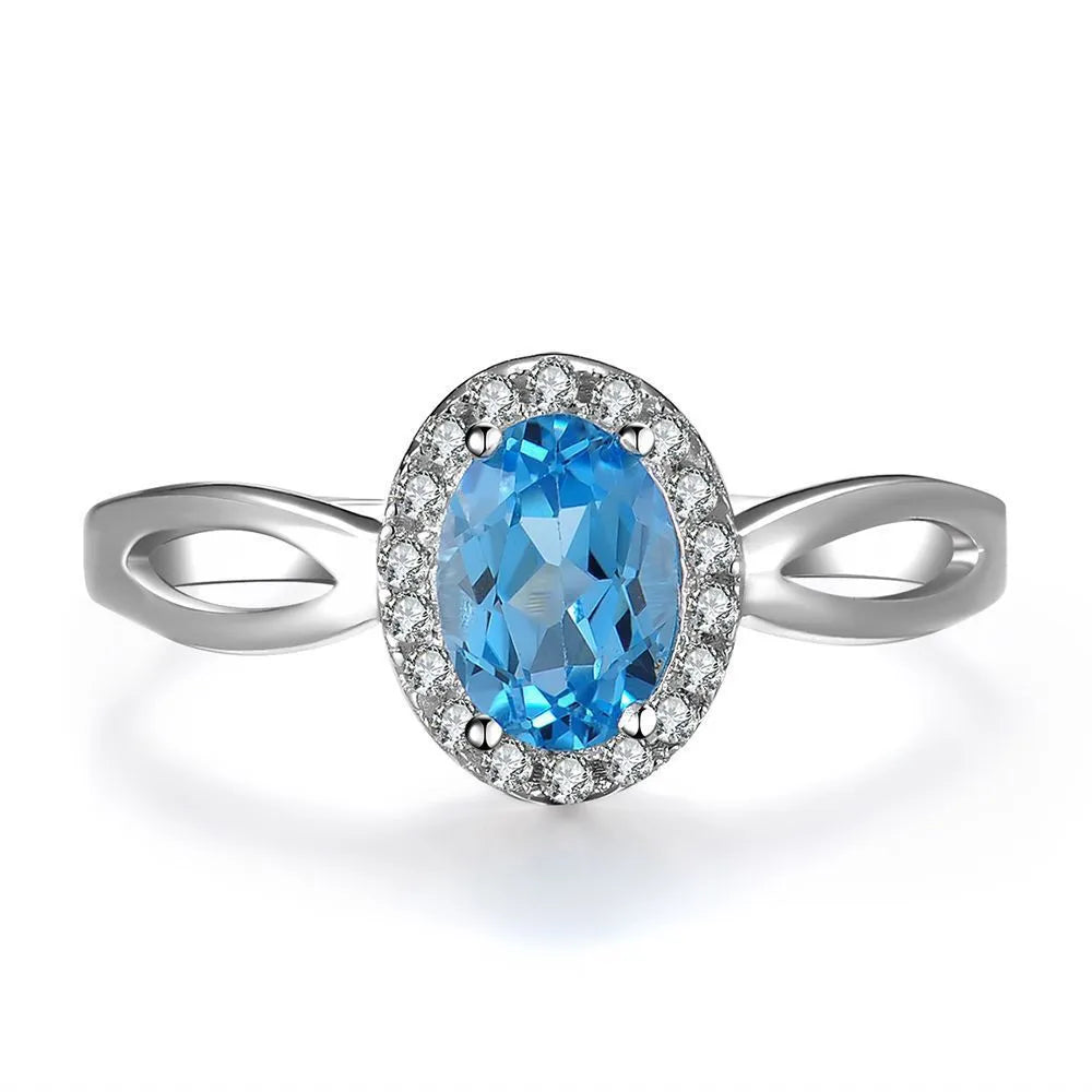 Women's sterling silver jewellery set with blue topaz gems featuring geometric earrings, ring, necklace and pendant