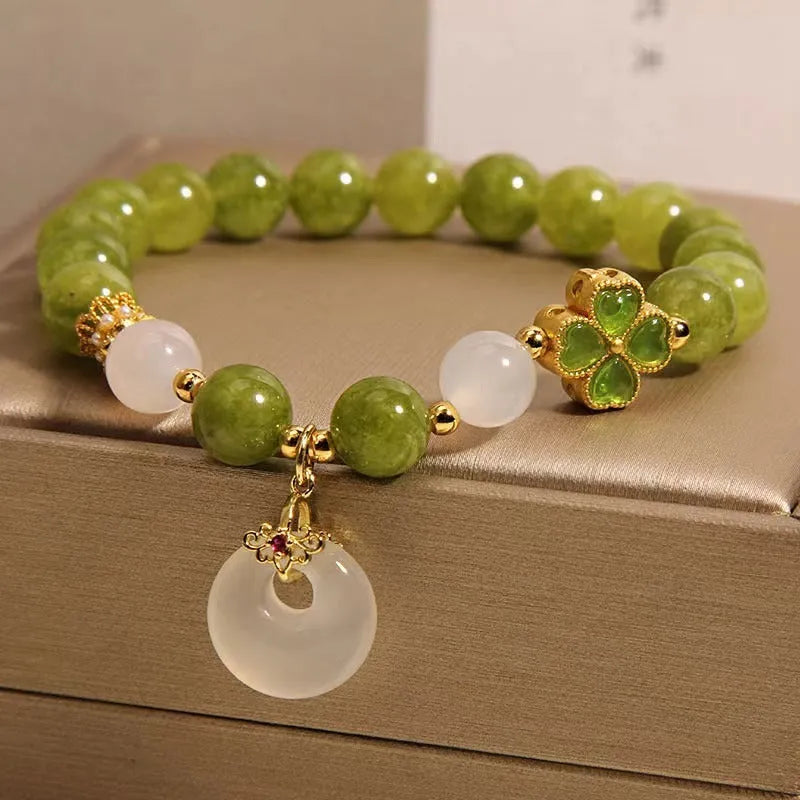 Natural stone green tourmaline women's bracelet with peace buckle and lucky bag charm on display