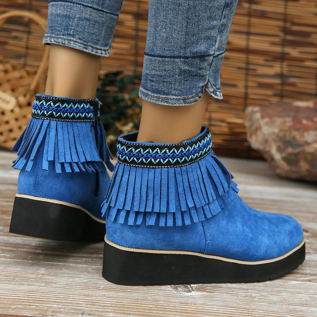 Women's dark brown suede ankle booties with a wedge heel, side zipper, and tassel detail