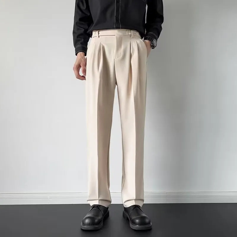 Men's apricot and black straight-leg suit trousers with a loose fit on a hanger.