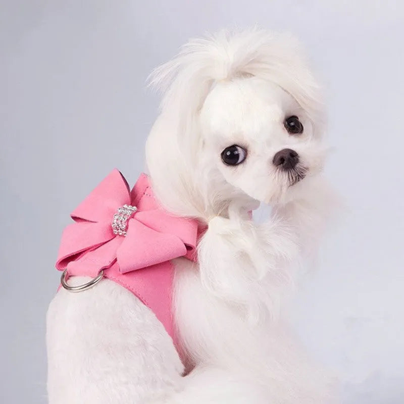 Pink microfiber dog chest strap with a large white bowknot, showing adjustment buckle and D-ring.