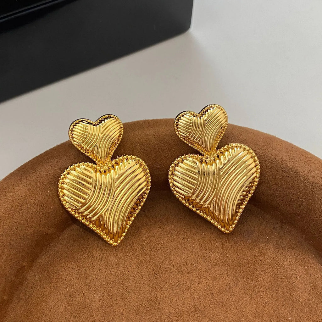 Double heart copper earrings with electroplated finish, available as ear clips or ear studs