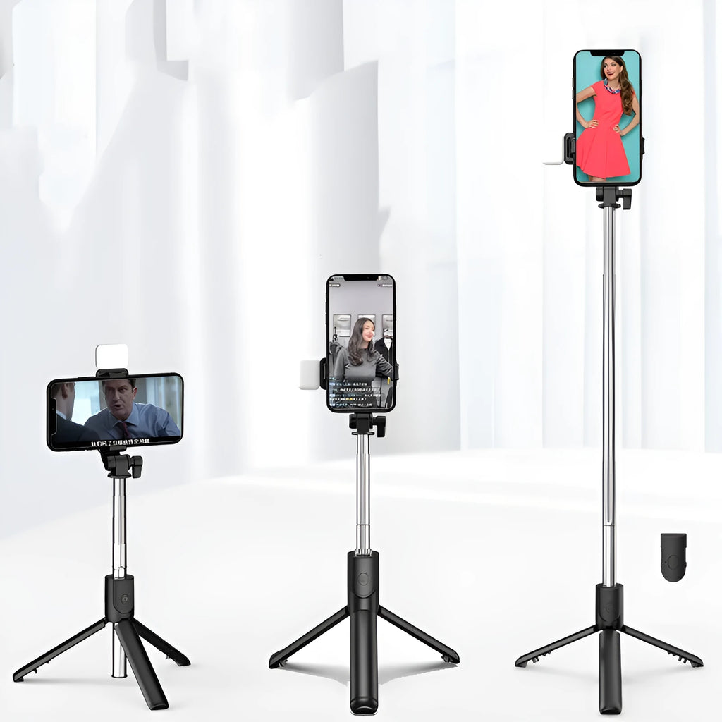 Black Bluetooth selfie stick with extended tripod legs and a fill light, holding an iPhone.