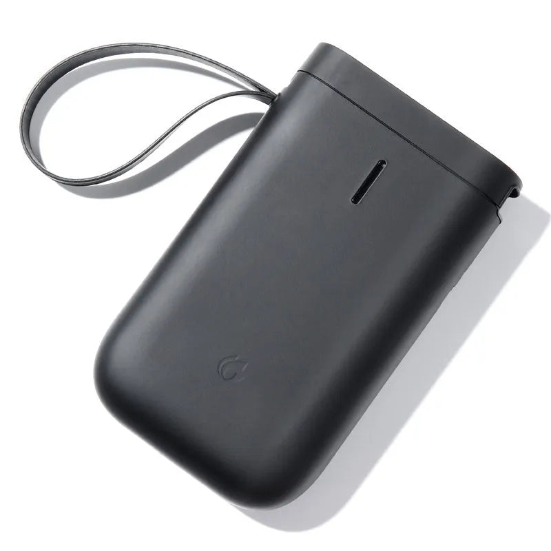 D11 compact black Bluetooth thermal label printer with LCD screen on a desk.