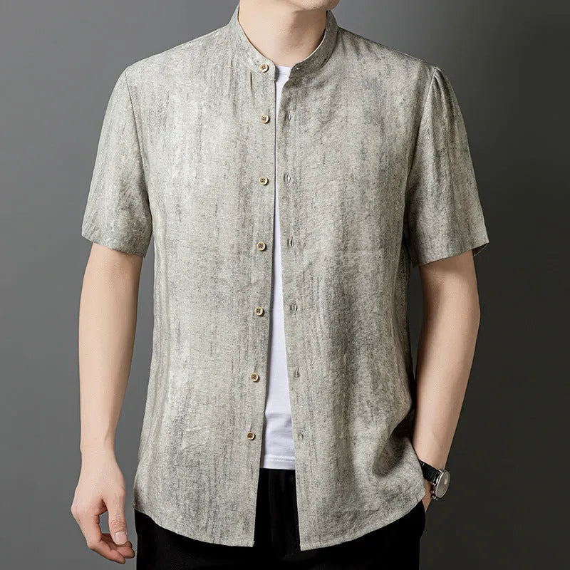 A man wearing a loose-fitting, short-sleeved casual shirt with a stand collar in a grey colour.