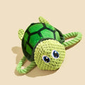 Grey, green, and orange turtle-shaped soft plush dog chew toy with internal knots.