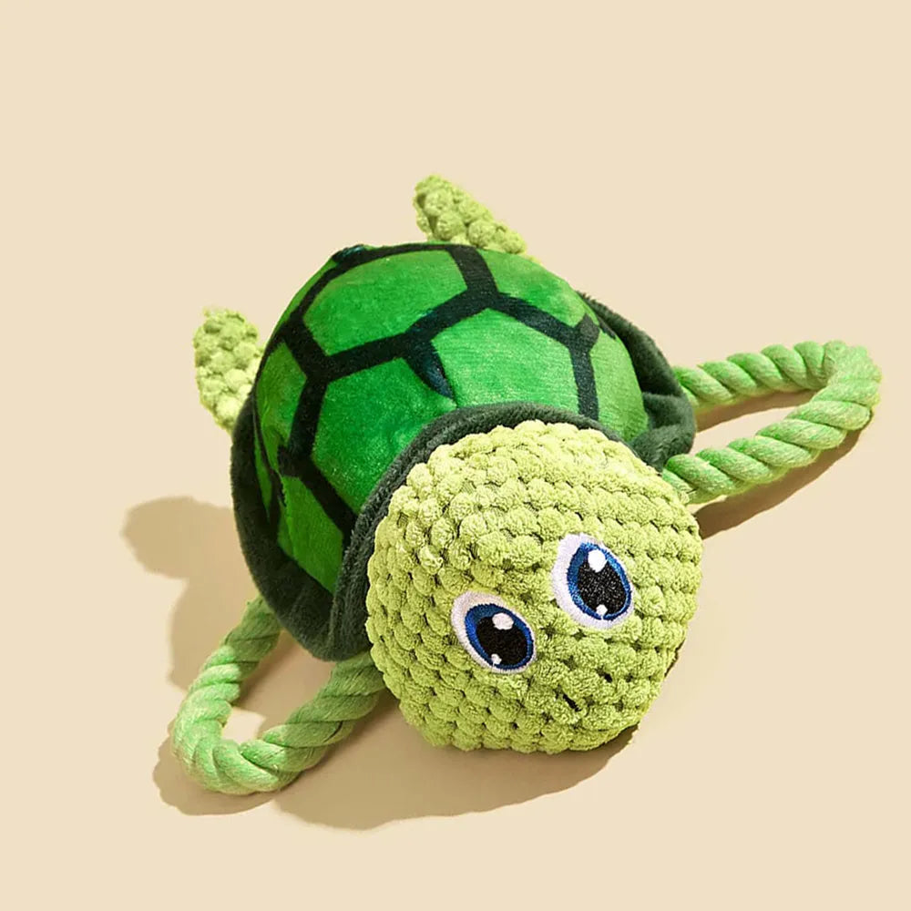 Grey, green, and orange turtle-shaped soft plush dog chew toy with internal knots.