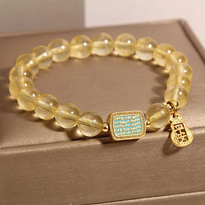 Natural citrine yellow crystal bracelet for women with rhinestone accents on a white background