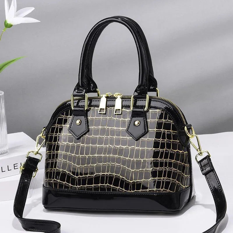 Women's solid colour shell shape PU handbag with metal hardware, zipper closure, and soft top handle