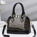 Women's solid colour shell shape PU handbag with metal hardware, zipper closure, and soft top handle
