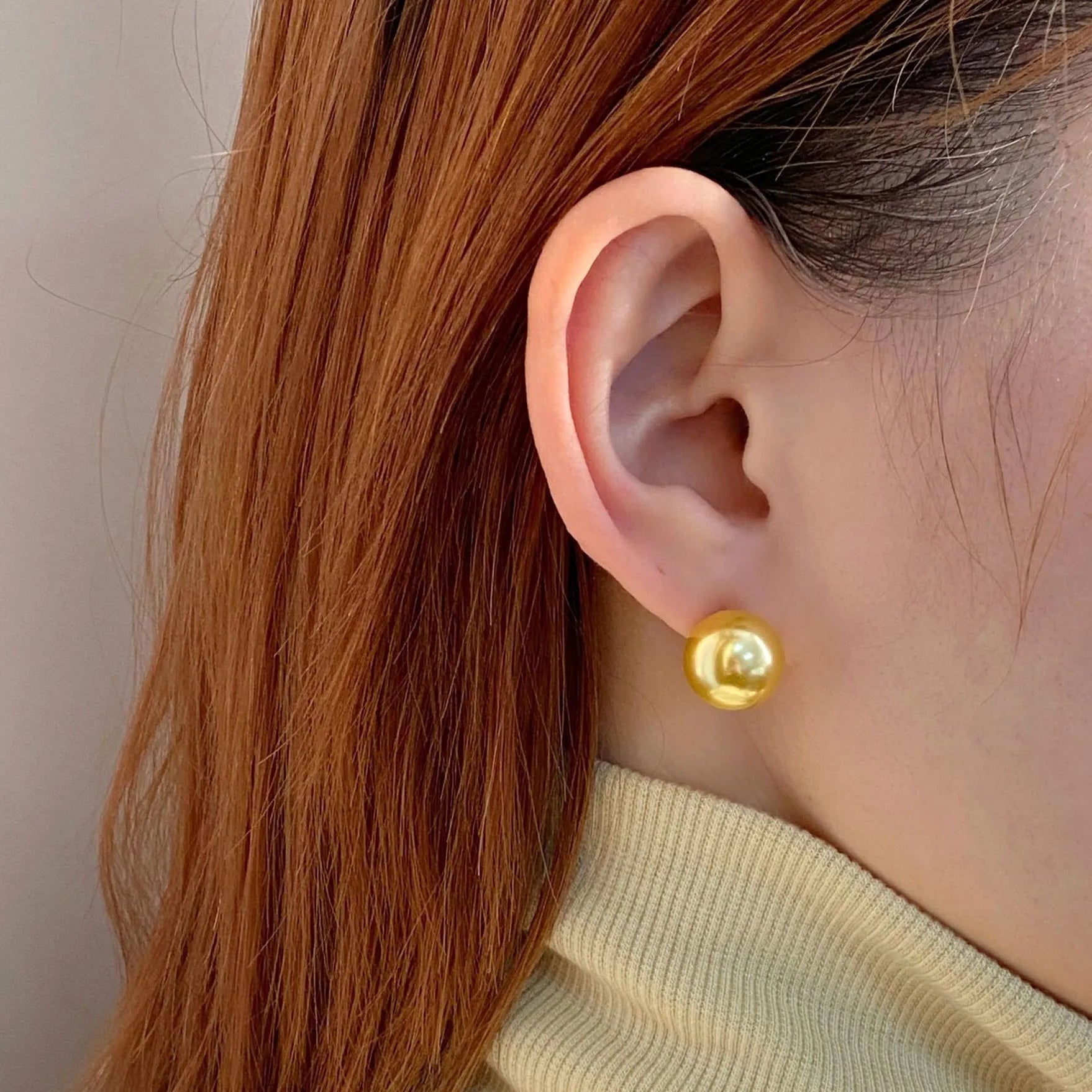 A pair of large geometric pearl stud earrings with an eight-point star accent on a silver setting.