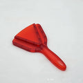 Telescopic red plastic can and bottle opener with adjustable length handle on a kitchen worktop.