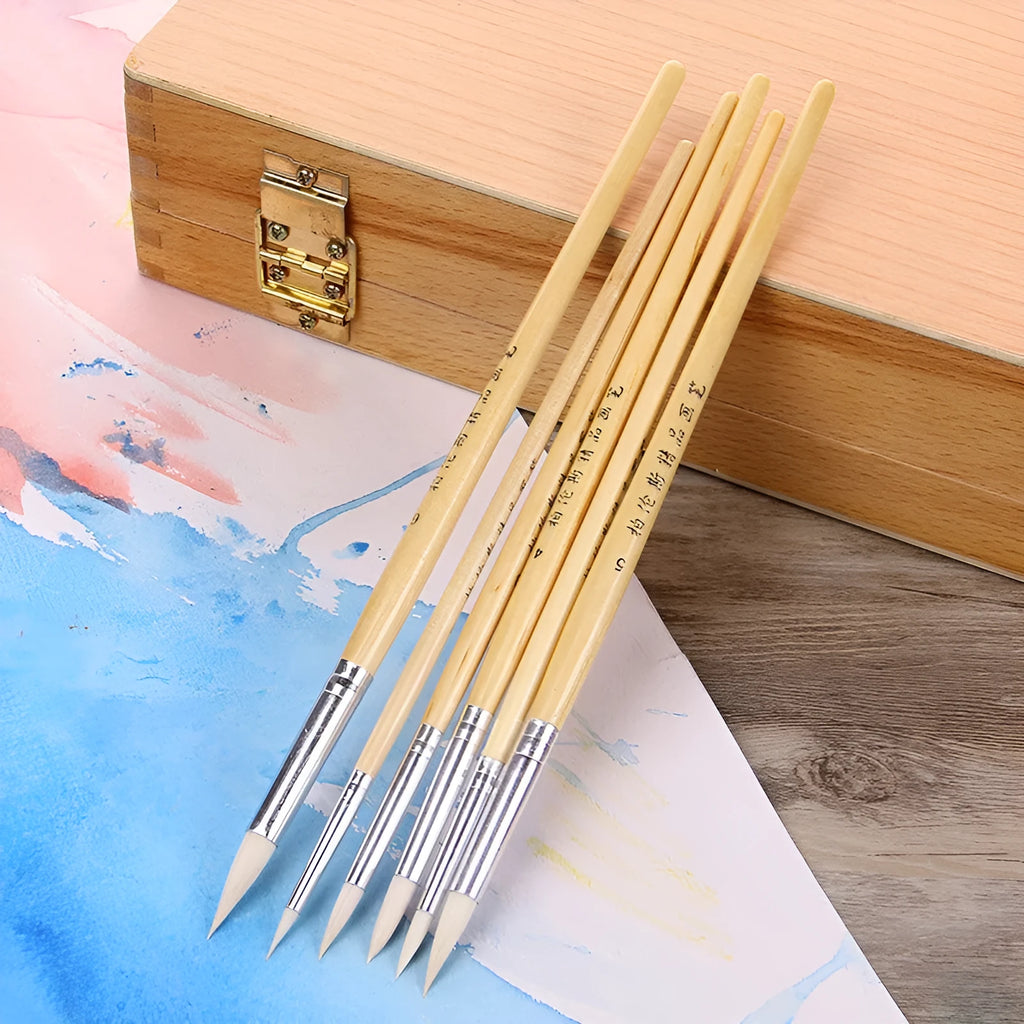 Six wooden handled artist brushes with pointed wool tips arranged as a complete set
