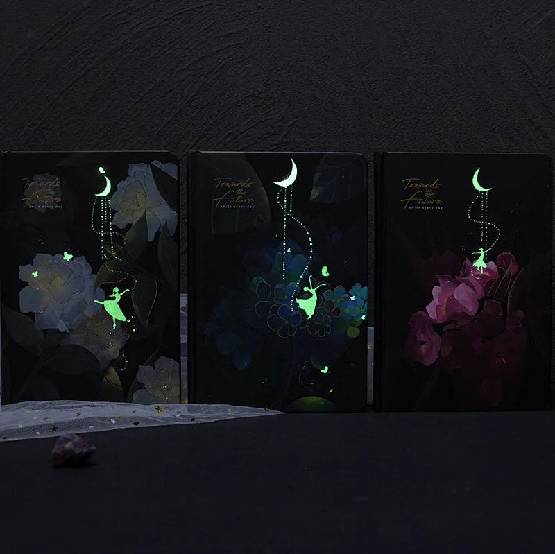 Four A5 hardcover notebooks with luminous covers in deep blue, gold, light blue, and purple colours.