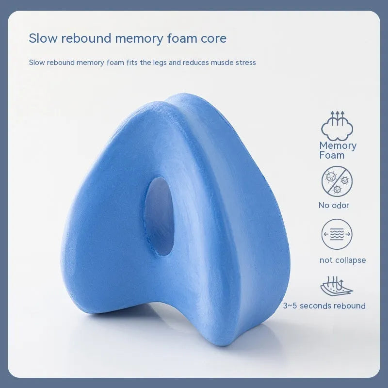 Heart-shaped dark blue jacquard memory foam leg pillow for adults on a bed.