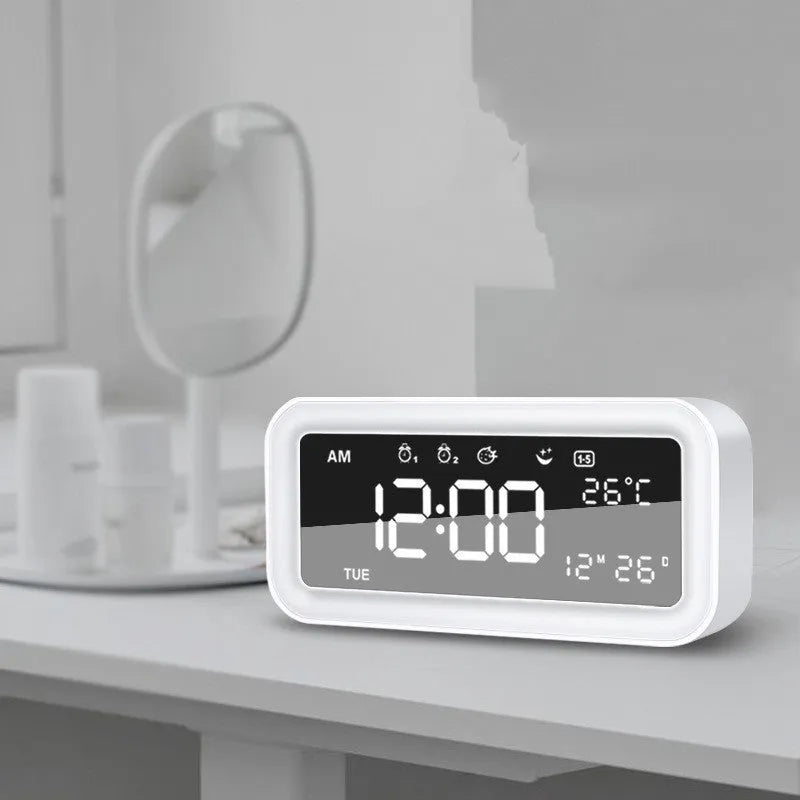 Blue rectangular LED digital alarm clock with atmosphere light on a bedside table.