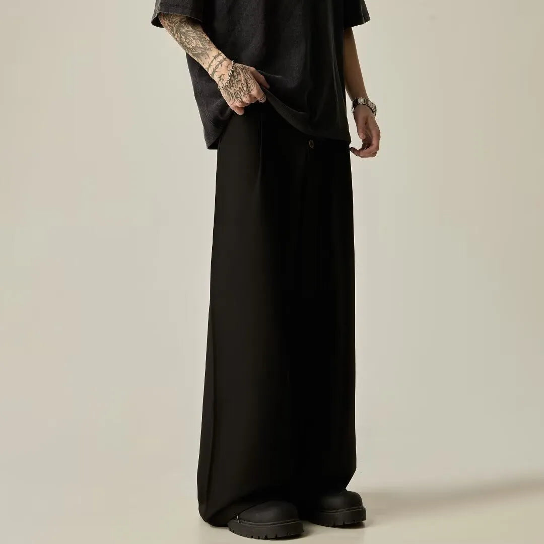 Men's solid black casual straight-leg trousers with a wide-leg fit and button fly on a neutral background.