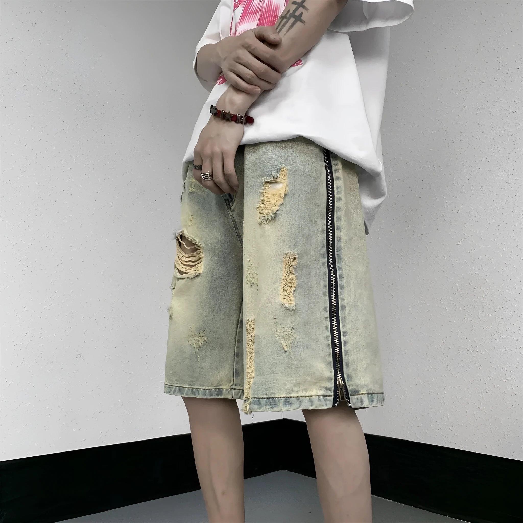 Men's loose five-point ripped denim shorts in blue with mud-yellow finish, button fly, and straight-leg cut