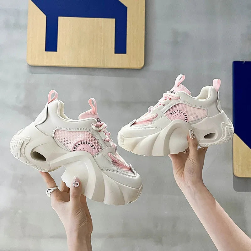Women's pink casual sneakers with cross shoulder straps, thick sole, and mesh lining on a white background.