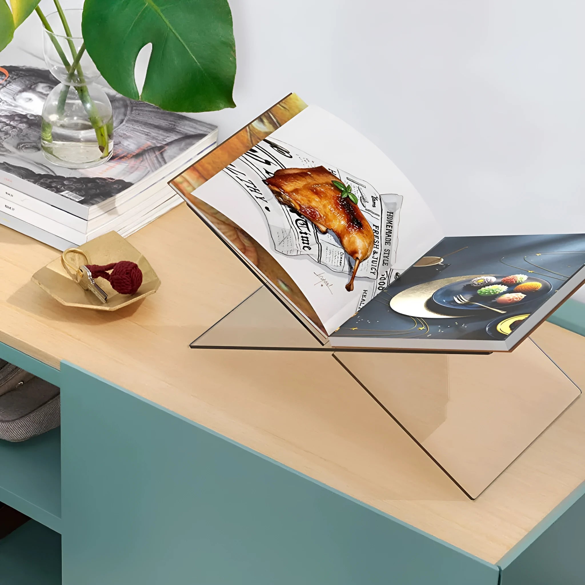 Clear acrylic X-shaped desktop book display rack holding multiple books at angle