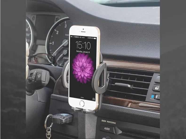Black car air vent mobile phone holder mounted on vehicle air conditioning outlet holding smartphone
