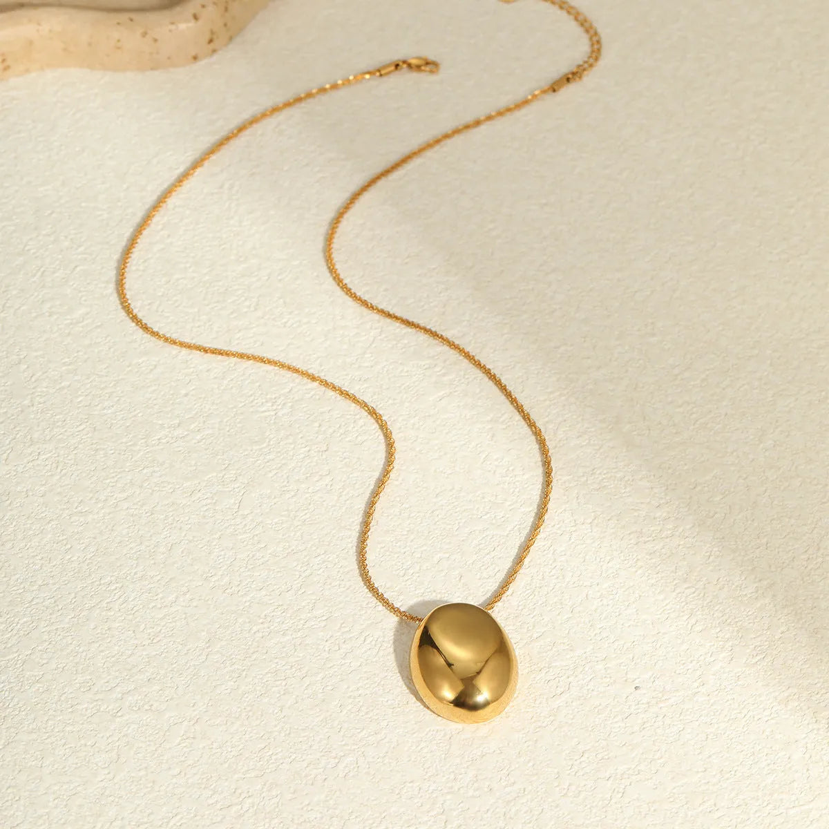 Gold geometric pendant on an adjustable stainless steel necklace chain.