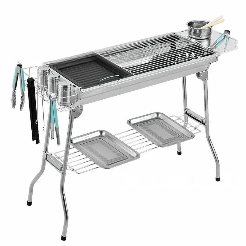 Stainless steel portable folding barbecue oven with large grill, shown outdoors.