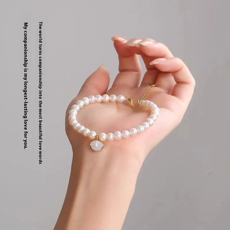 Freshwater pearl bracelet with fan-shaped shell design showing pearls on elastic or chain option