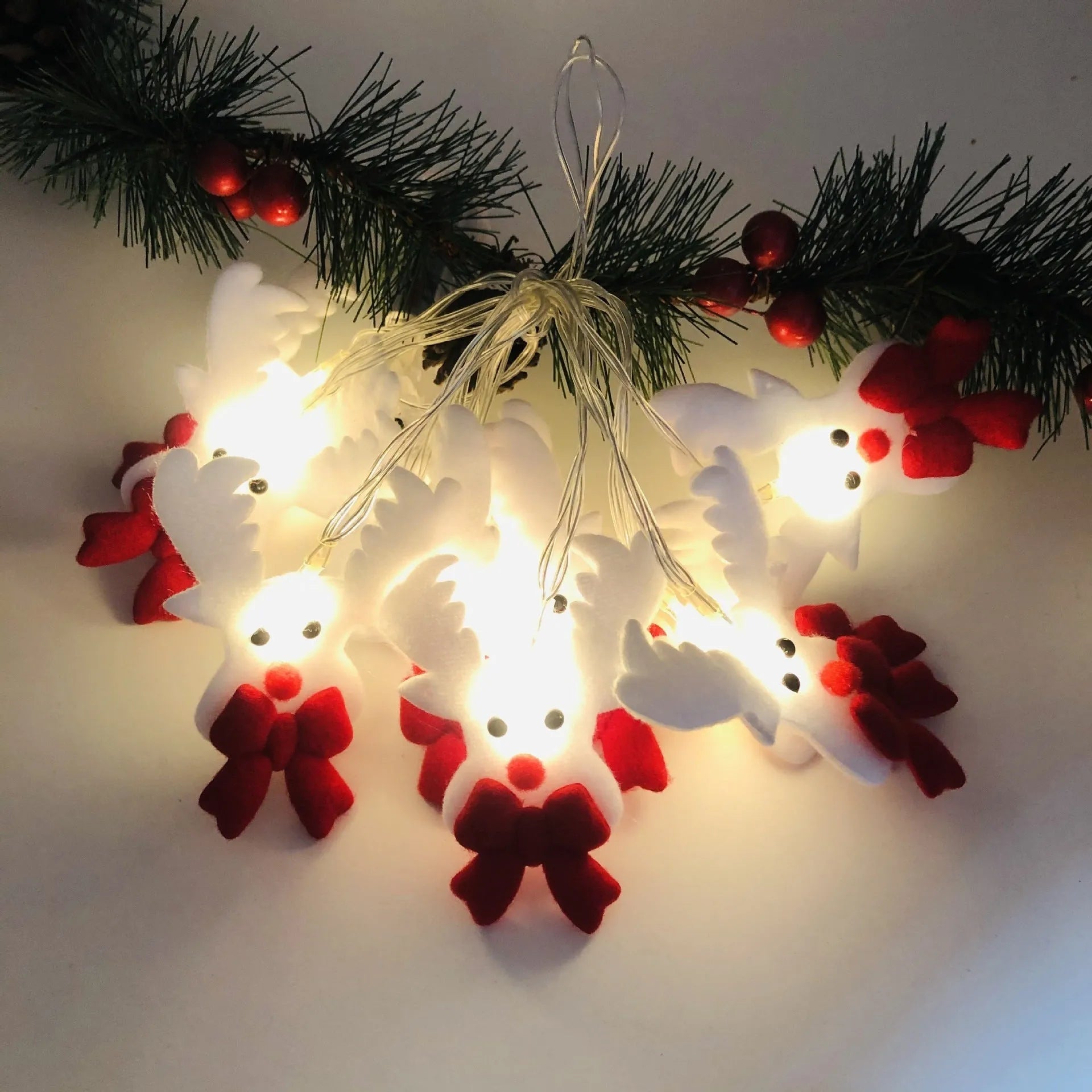 Christmas LED string lights with warm white glow showing snowman and elk deer themed lamps on a dark background